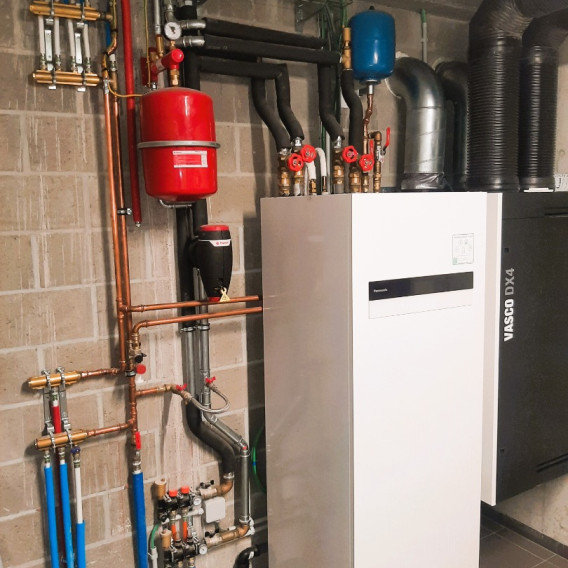 Technische ruimte met warmtepompinstallatie en leidingwerk, geplaatst door Elektro Moerenhout