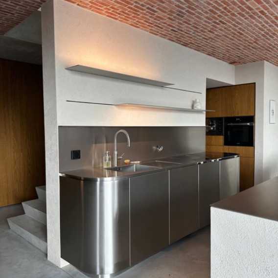 Inox keuken onder gewelfd baksteenplafond in een loft in Merchtem