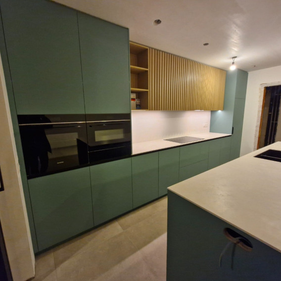 Groene maatkeuken met inbouwovens en houten lamellenwand, HVV Puurs