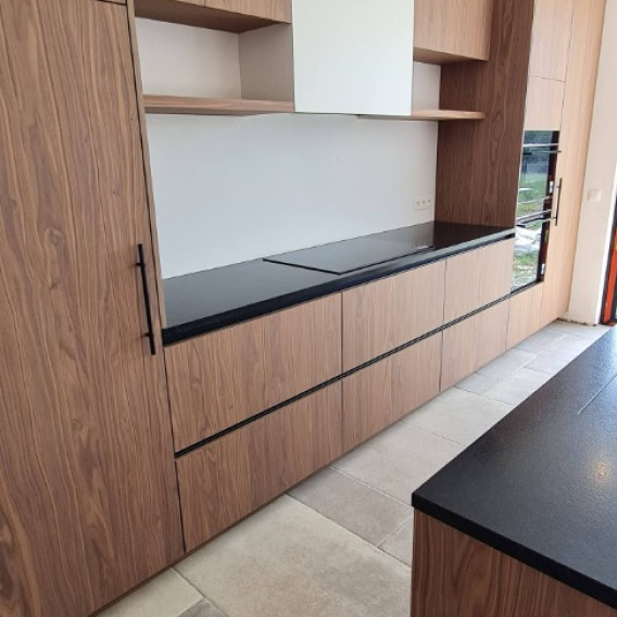 Notenhouten keukenwand met zwart werkblad en inbouwkookplaat, Langevelde Merchtem
